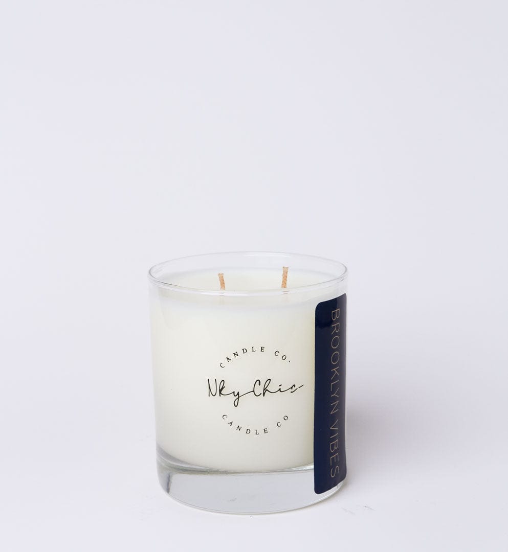 White candle in a glass jar with a label on a white background