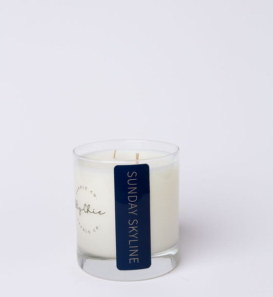 White candle in a glass jar with a blue label on a white background