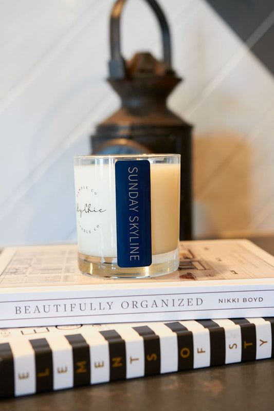 Candle with a label on top of books, with a blurred background